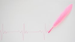 EKG with pink feather on blank background