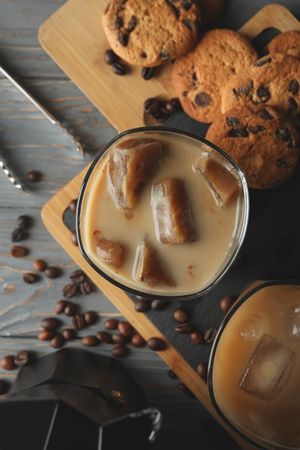 Composition with ice coffee and cookies on wooden background