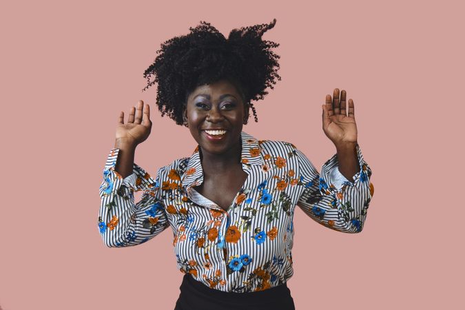 Portrait of confident and happy Black woman with her arms up