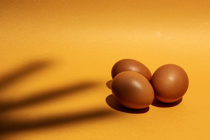 Fresh raw eggs on brown background