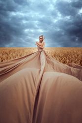 Woman in big brown dress posing in wheat field