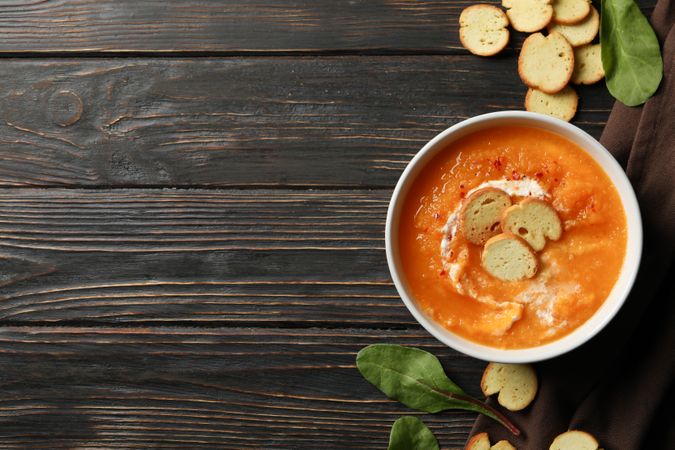 Top view of bowl of delicious pumpkin soup on table, copy space