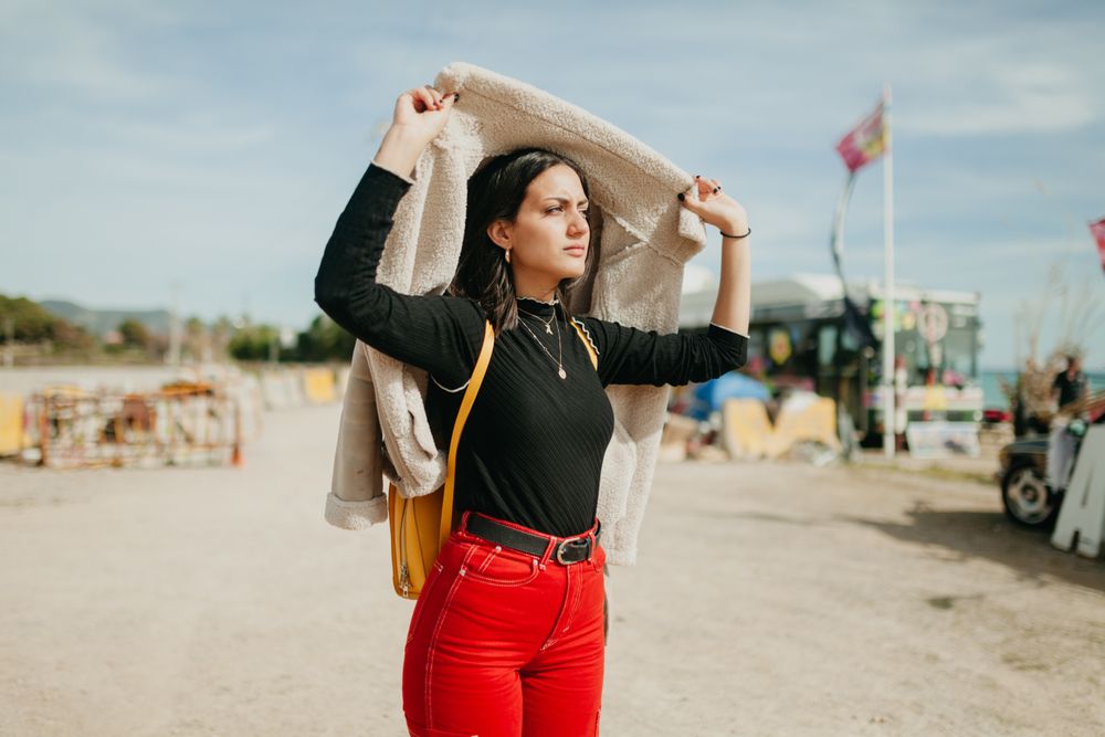Stylish woman with jacket on beach