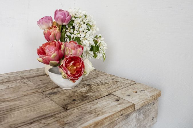Bowl of beautiful flowers on wooden table