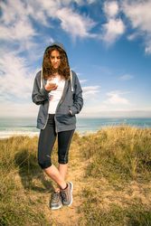 Woman checking phone in front of ocean path