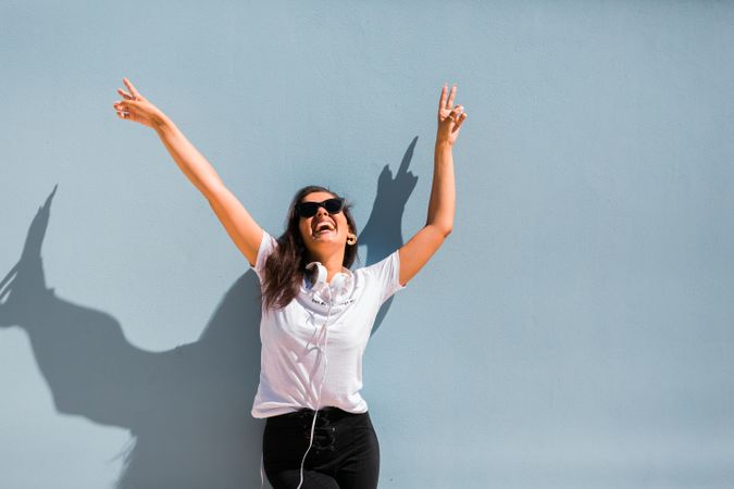 Cheerful casual woman in sunglasses standing on city street