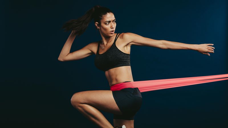 Fitness woman working out with resistance band
