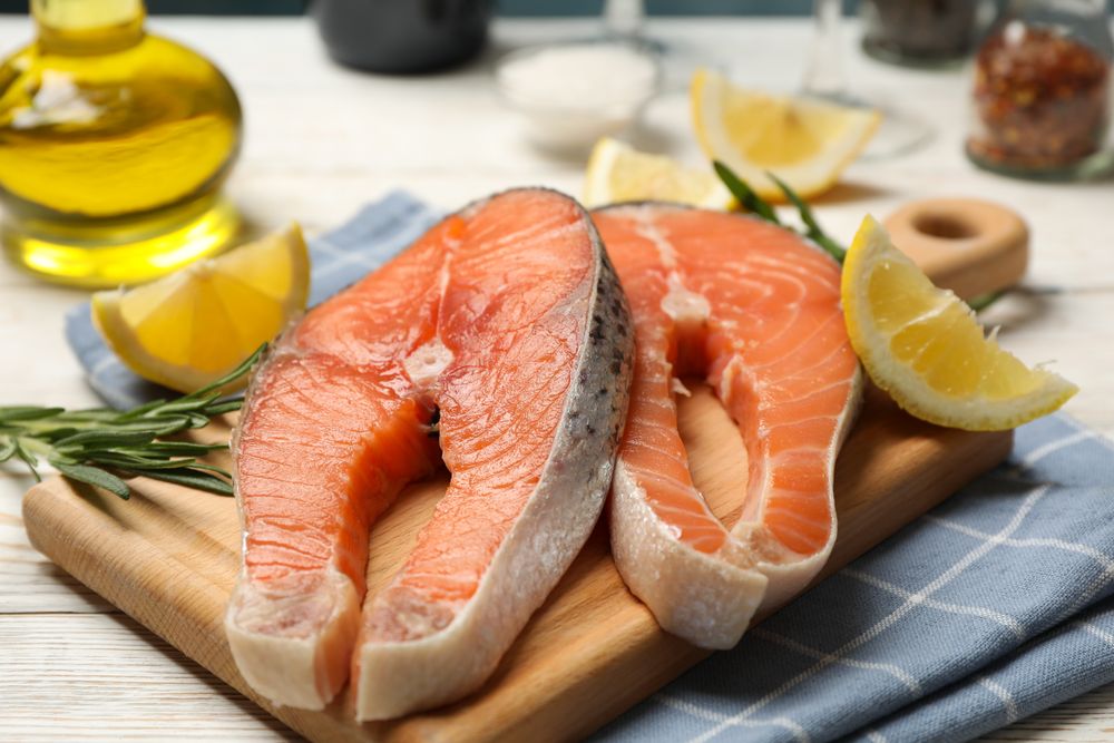 Composition with salmon meat and spices on wooden background, close up