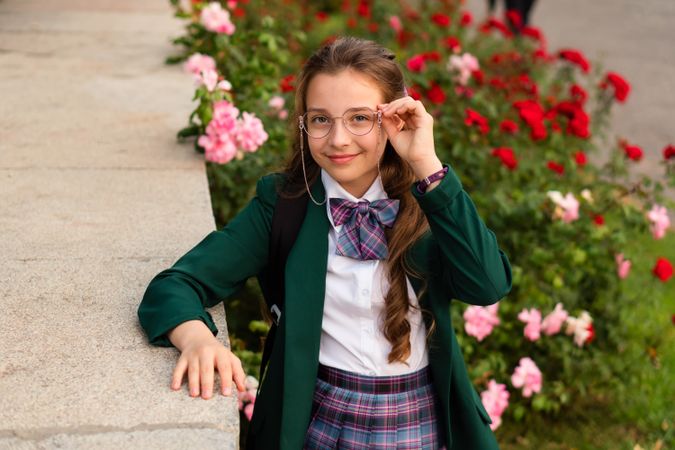 Young girl in school uniform adjusting her glasses