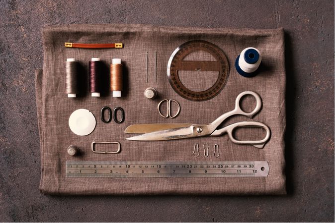 Sewing kit laid out on brown fabric
