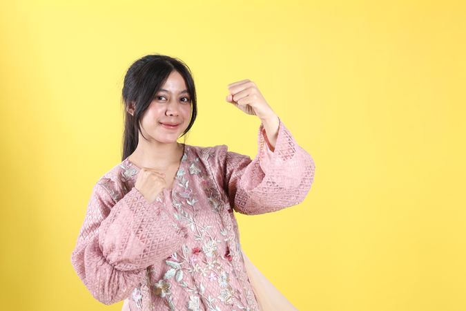 Excited Indonesian Woman Wearing Kebaya Standing with Clenched Hands Pose