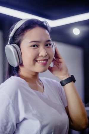 Joyful Asian Woman Enjoying Music with Wireless Headphones Indoo
