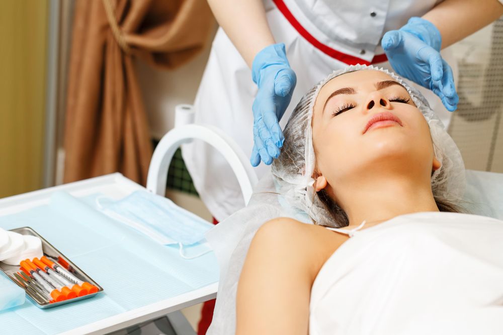 Cosmetologist at med spa prepping female client before treatment