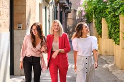 Smiling women walking on street together