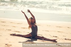 Woman doing splits on a beach near the seaside 5az1a4