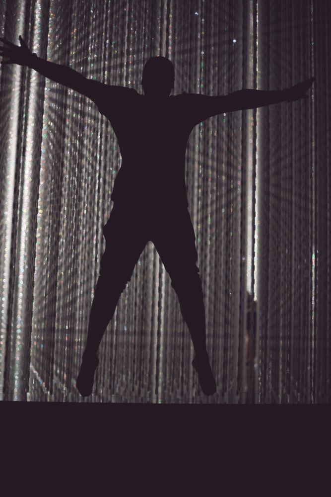 Tokyo, Japan - November 19th, 2019: Man star jumping in front of crystalline installation