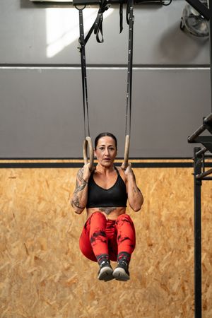 Woman training with olympic rings in a gym