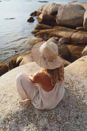 Carefree woman enjoying rest on coast near cliffs