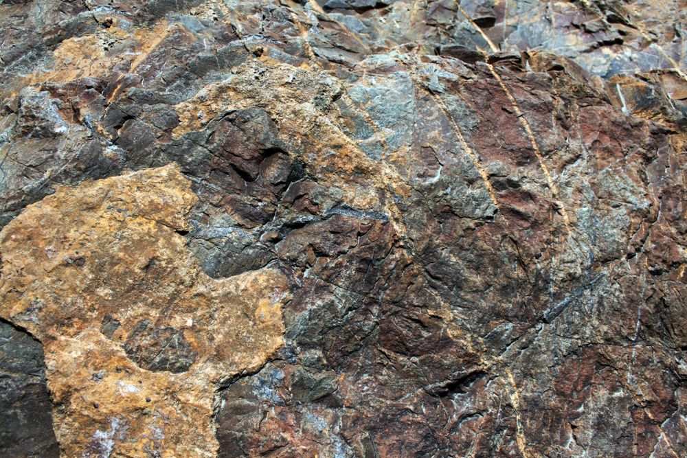 Dark and light brown rock face with amber red undertones