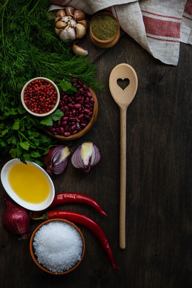 Top view of wooden table with kidney beans, garlic, chili and seasonings