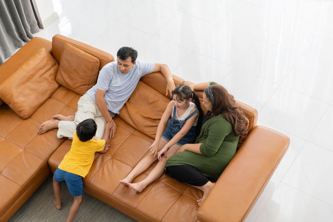 Top view of Asian family talking together on couch in the living room