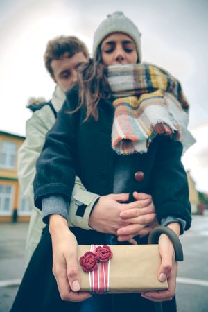 Woman holding giftbox from boyfriend holding her