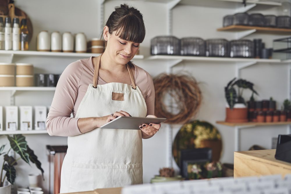 Florist preparing billing on tablet in her shop