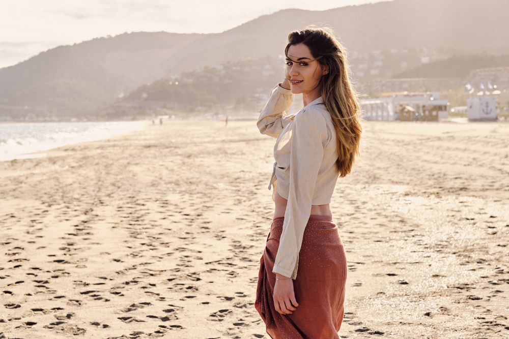 A fashion model at the beach before sunset