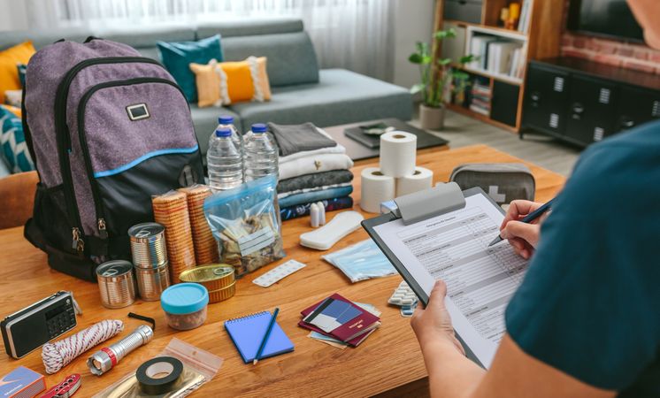 Woman doing checklist of emergency backpack