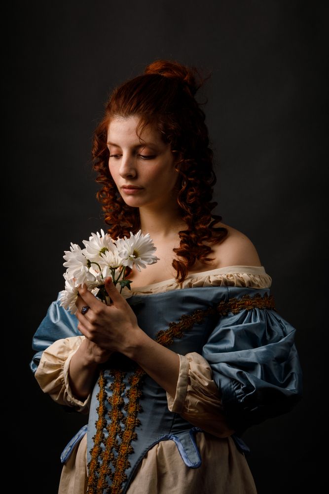 Baroque woman with closed eyes holding flowers