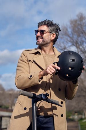 Smiling man with scooter in park