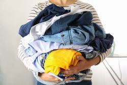 Young woman hold crumpled clothes, space for text