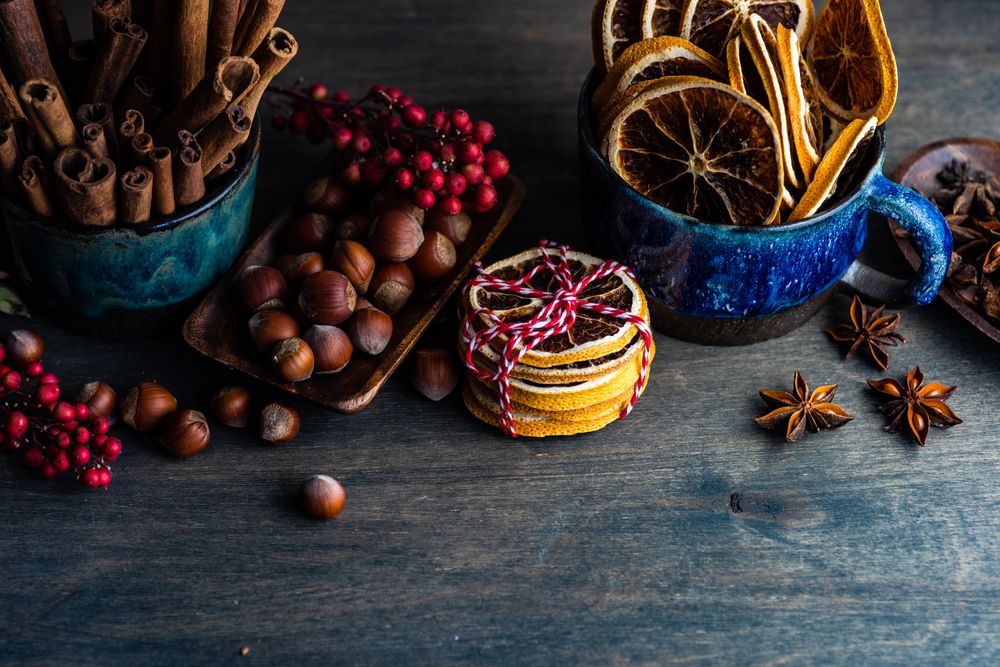 Table of fragrant Christmas items like orange slices, nuts and spices