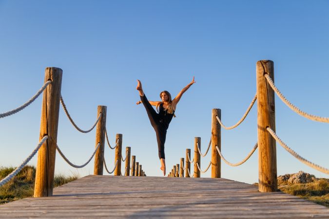 Woman posing in air on footbridge