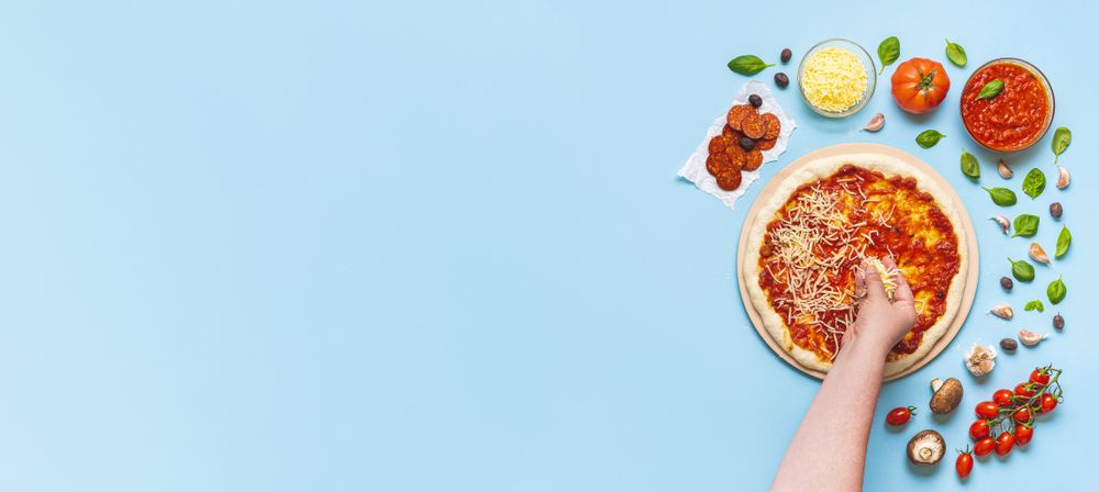 Putting cheese toppings on pizza