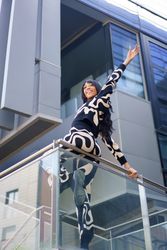 Cool woman on a rail gazing the city from skyscraper