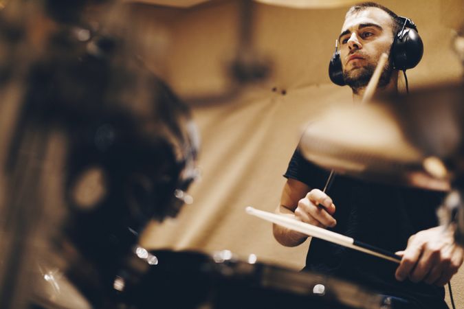 Man with headphones playing on drums