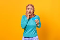 Muslim woman surprised and holding credit card