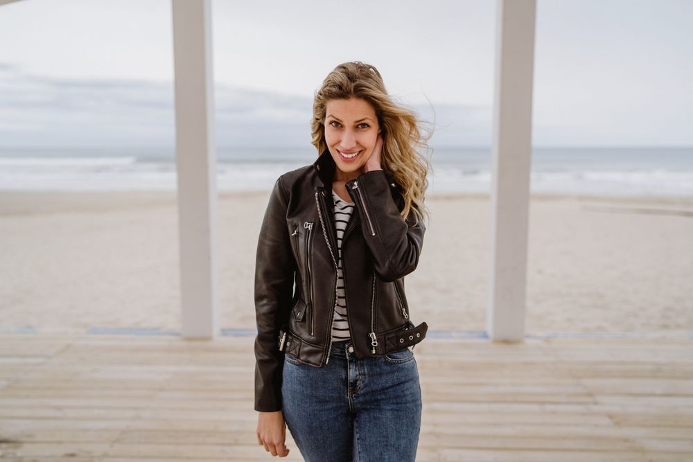 Woman on white wooden pier with ocean on background