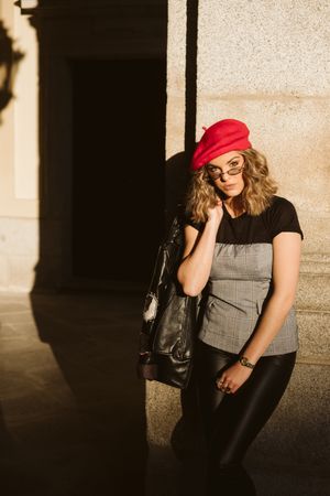 Stylish female standing near building wall