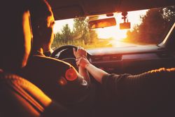 Inside of vehicle with man driving and passenger holding his hand