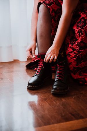 Woman in dress lacing boots