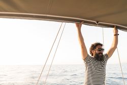 Smiling man on yacht on water