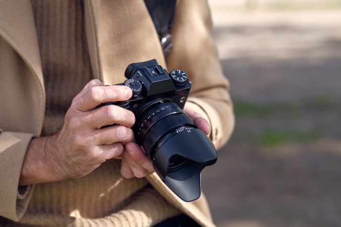 Crop male photographer taking photos on camera
