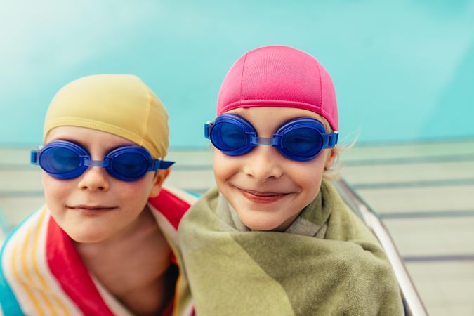 Two siblings smiling and having fun at swim lesssons
