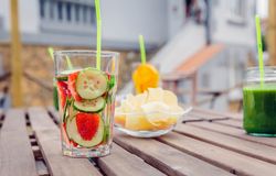 Snacks and fresh fruit drinks on empty table outside