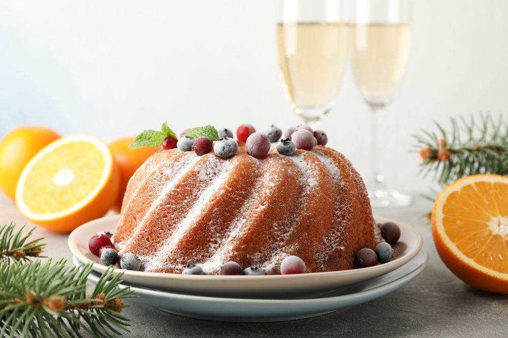Cake with powder sugar and berries on grey table. Happy new year concept