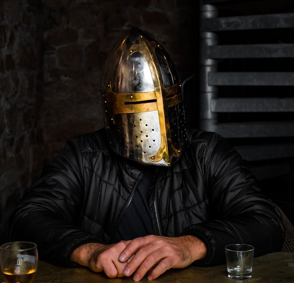 A man in a medieval iron knight's helmet.