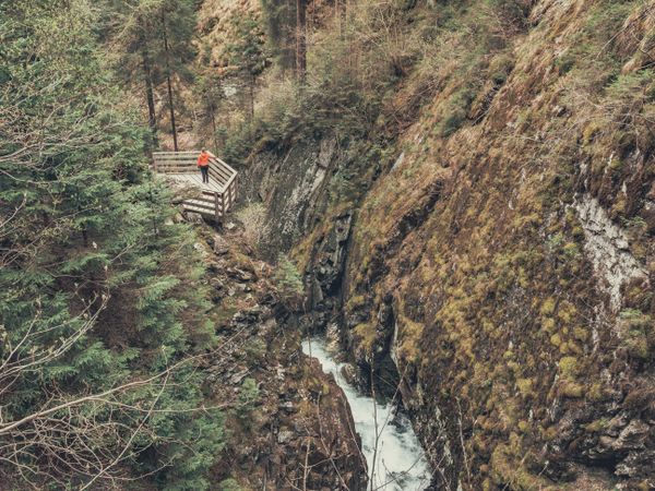 Traveller admiring picturesque view of mountain stream