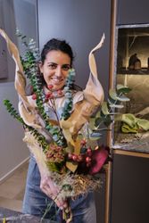 Smiling woman with composition of flowers in floristry wor